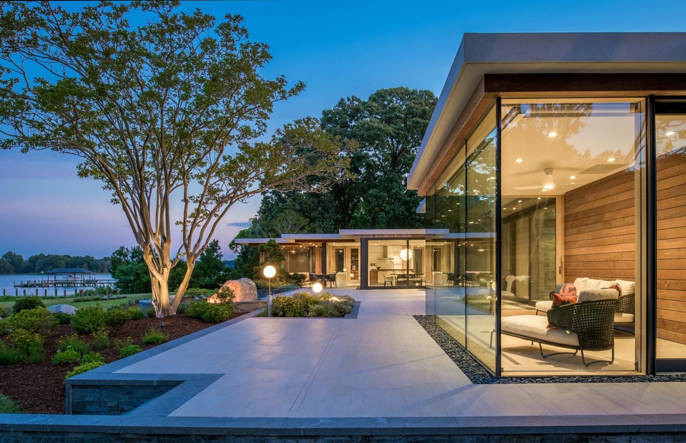 Custom home with floor to ceiling windows overlooking the water